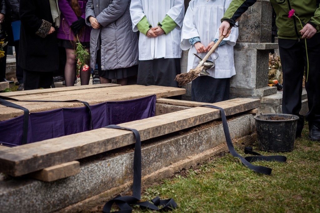 burying a coffin at a cemetery