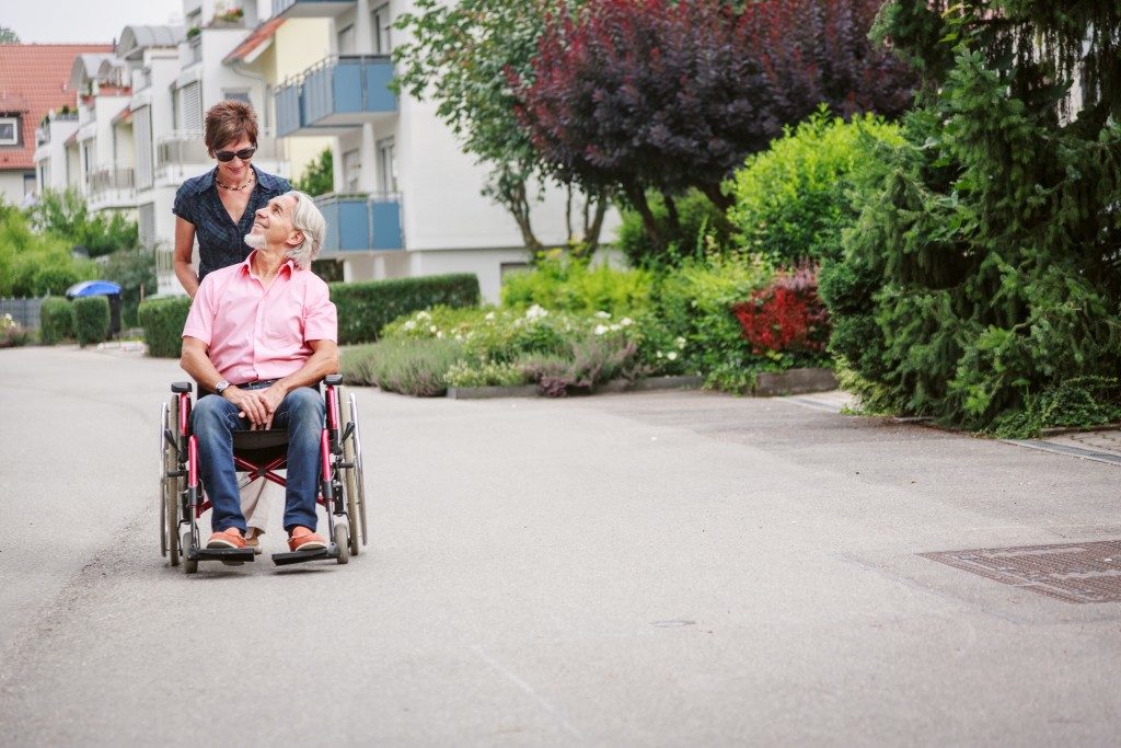 senior man in wheel chair with his daughter getting fresh air