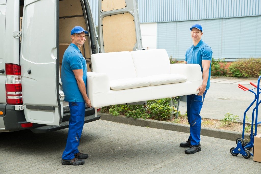 Two workers putting furniture down from truck
