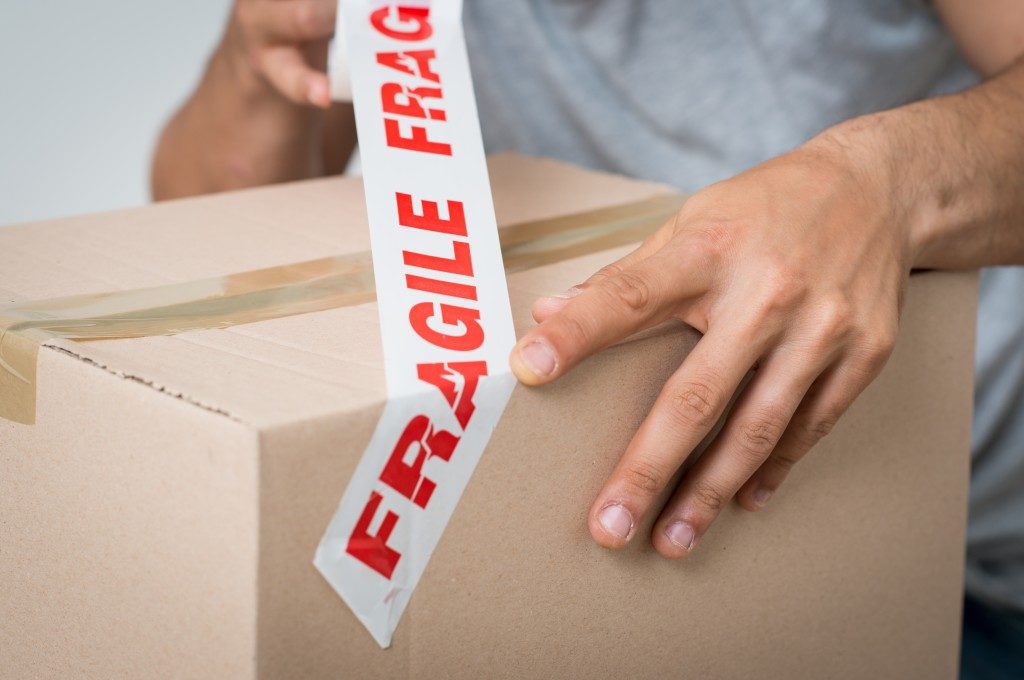 Box being taped with "fragile" sign