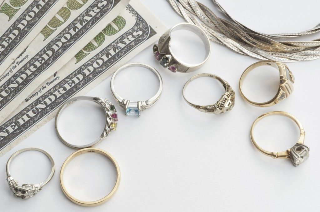 money and jewelries on top of a white table