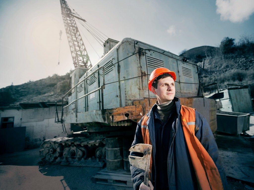 man posed in front of the excavator