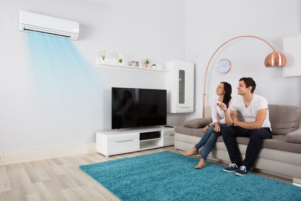 couple in the living room turning the airconditioner