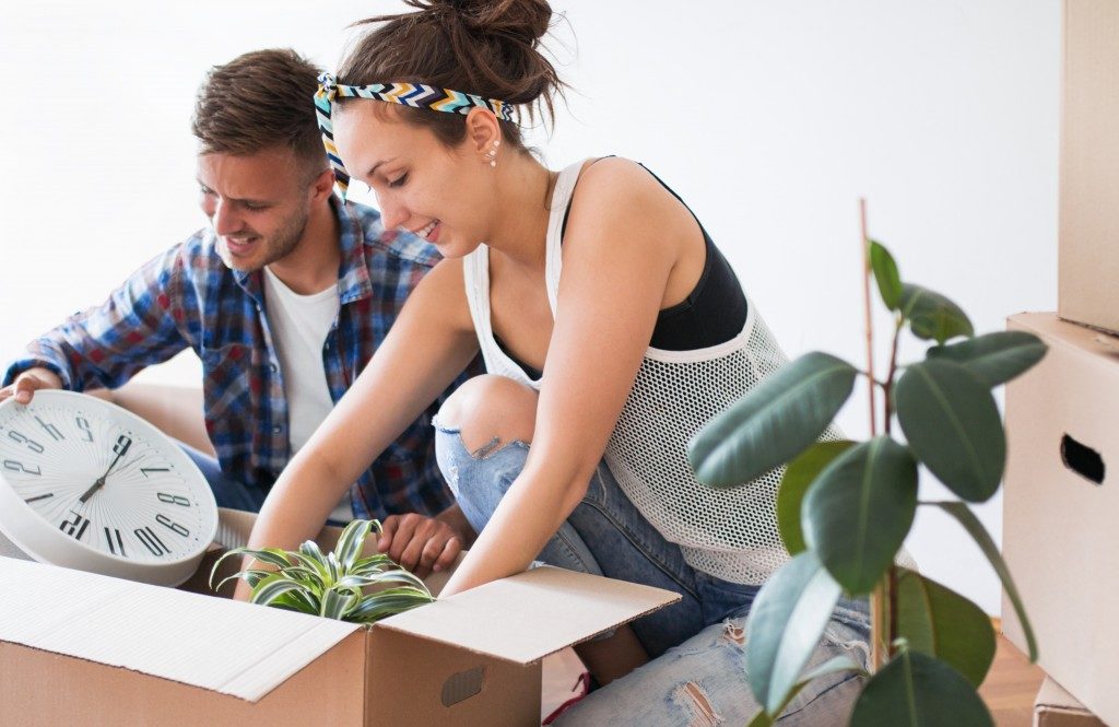 Couple unpacking boxes in new house