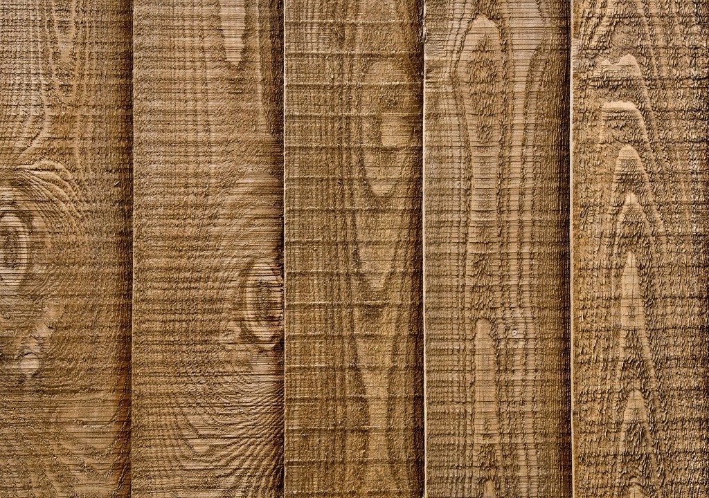 A close up section of wooden garden fencing with vertical, overlapped panels