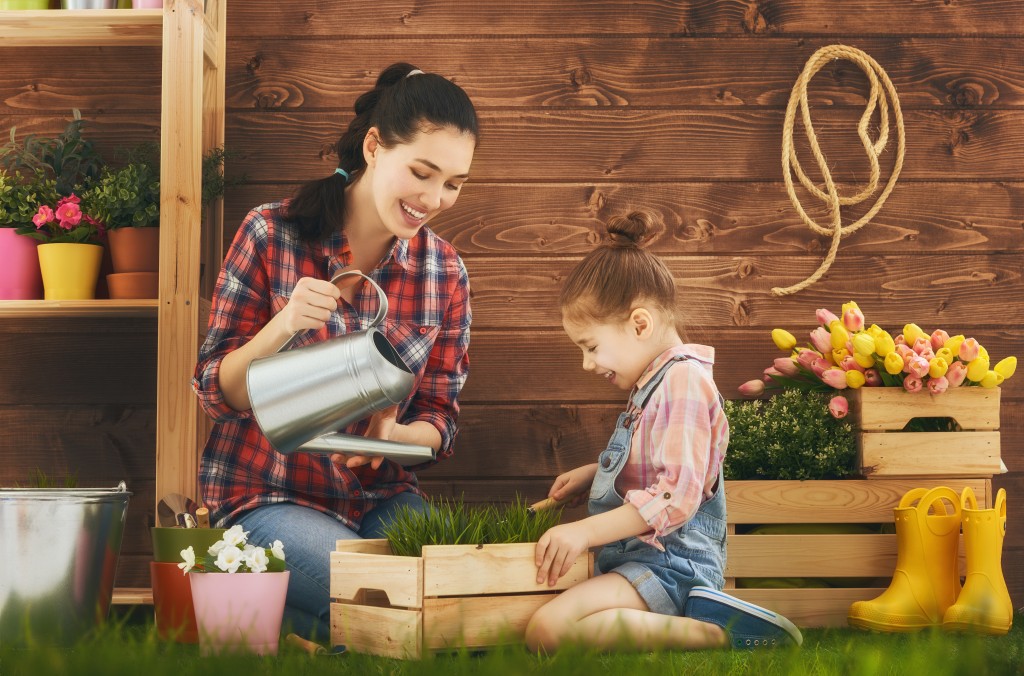  Mother and her daughter engaged in gardening in the backyard