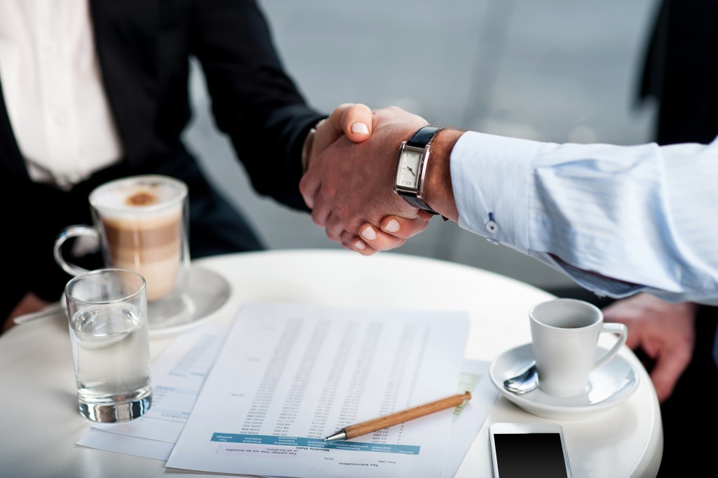 businesspeople shaking hands in an outdoor meeting
