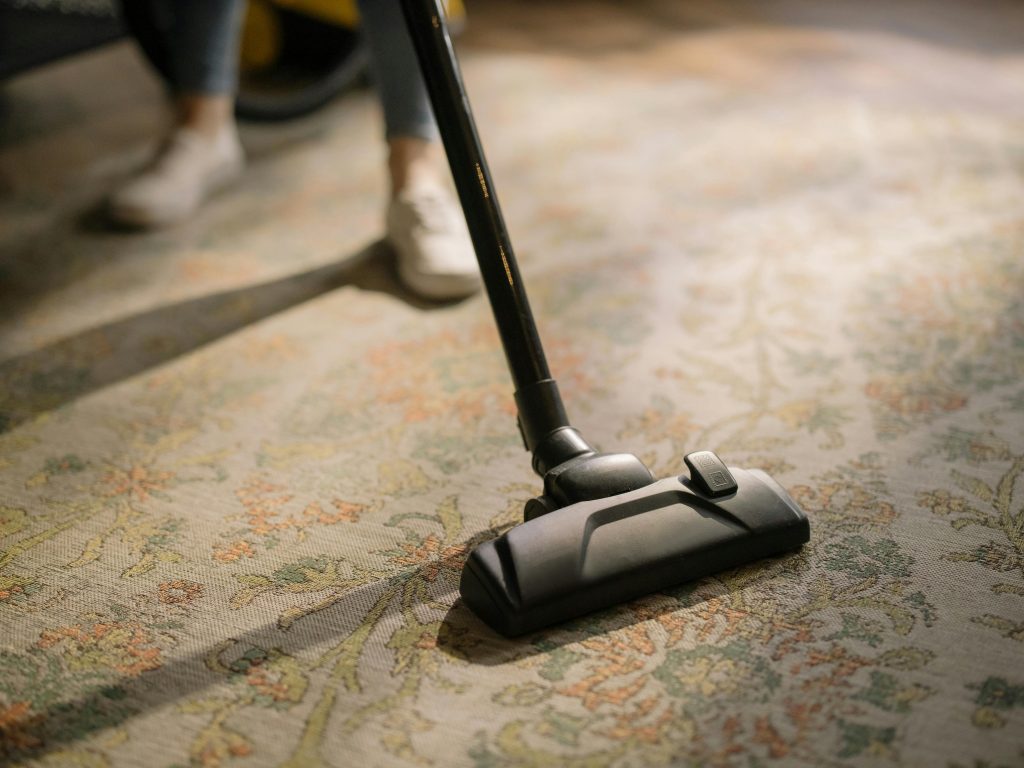 person vacuuming carpet flooring